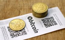 Монеты Биткоина лежат на бумажном кошельке Bitcoin