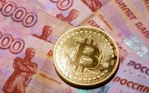 Монета Биткоина лежит на российских рублях