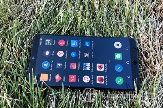 Смартфон Meizu 15 Plus лежит на траве
