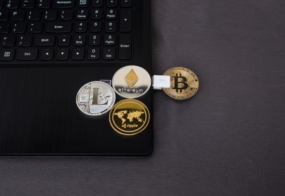 Монеты нескольких криптовалют лежат на ноутбуке