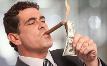 Бизнесмен подкуривает сигару долларом