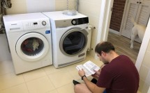 Парень изучает инструкцию по использованию сушильной машины