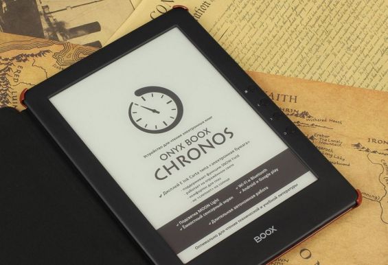 Электронная книга ONYX BOOX Chronos лежит на листах бумаги