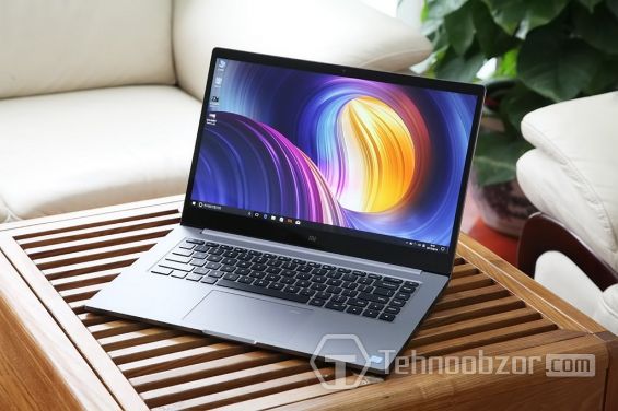 Xiaomi Mi Notebook Pro стоит на деревянной поверхности