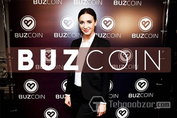 Ольга Бузова на фоне стенда с эмблемой Buzcoin