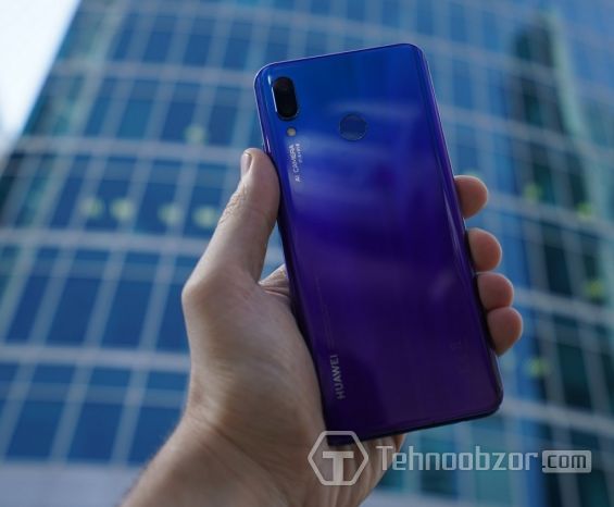 Телефон Huawei Nova 3 на фоне небоскреба