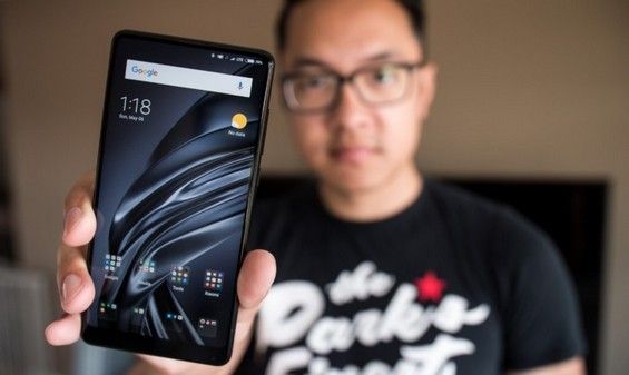 Мужчина держит Xiaomi Mi MIX 2S перед собой