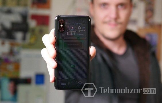 Парень держит в руке Xiaomi Mi 8 Pro